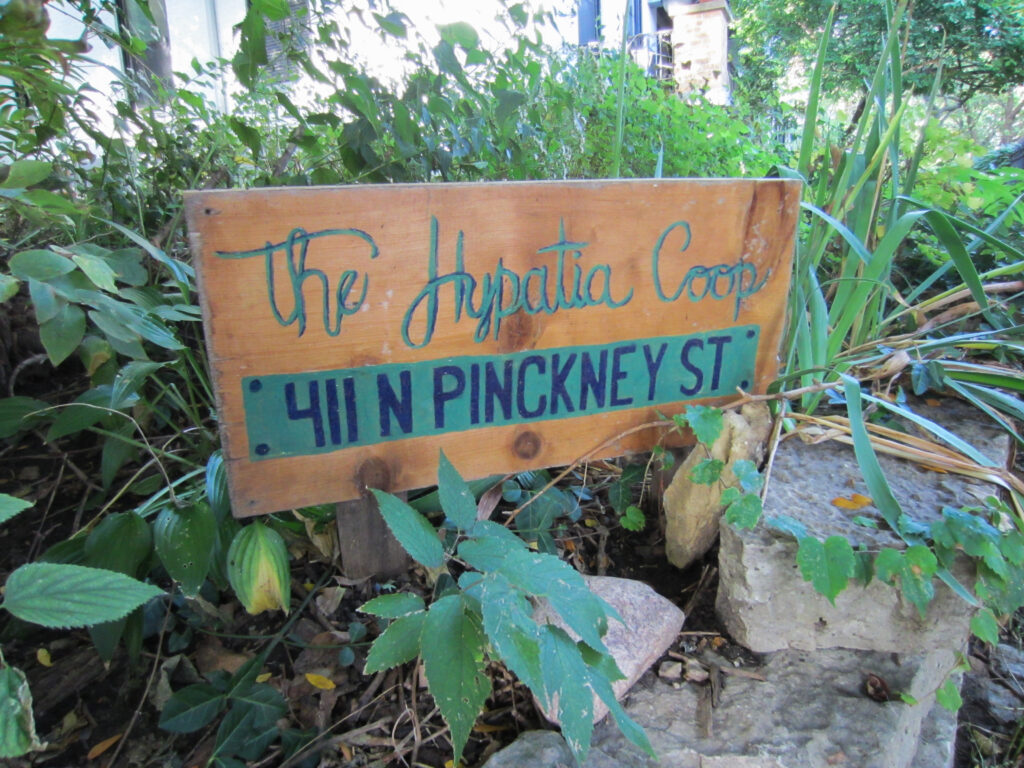 Painted wooden sign says "The Hypatia Coop, 411 N Pickney St"